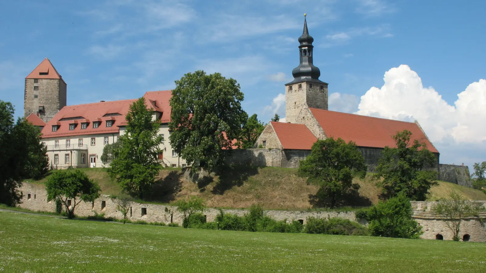 Burg Querfurt mit Bergfried, Burgkirche und Wehrmauer über einer Wiese