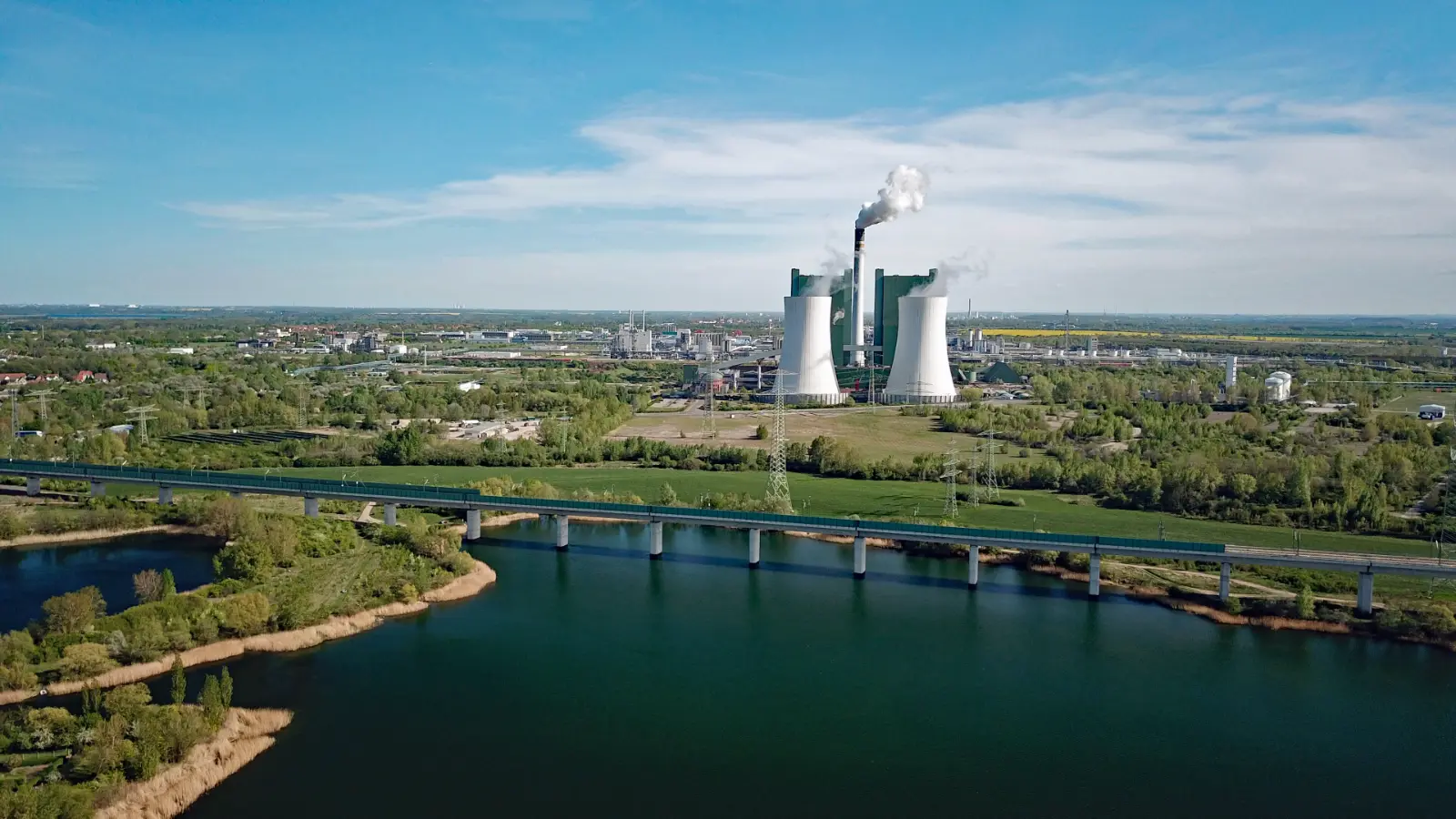 Luftbild im Saalekreis: Kraftwerk Schkopau und Chemiepark hinter einem See mit Eisenbahnbrücke